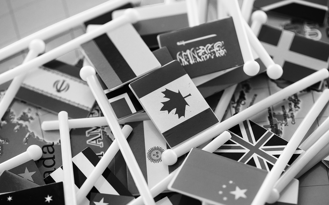 A small pile of plastic toy flags representing nations from across the globe.