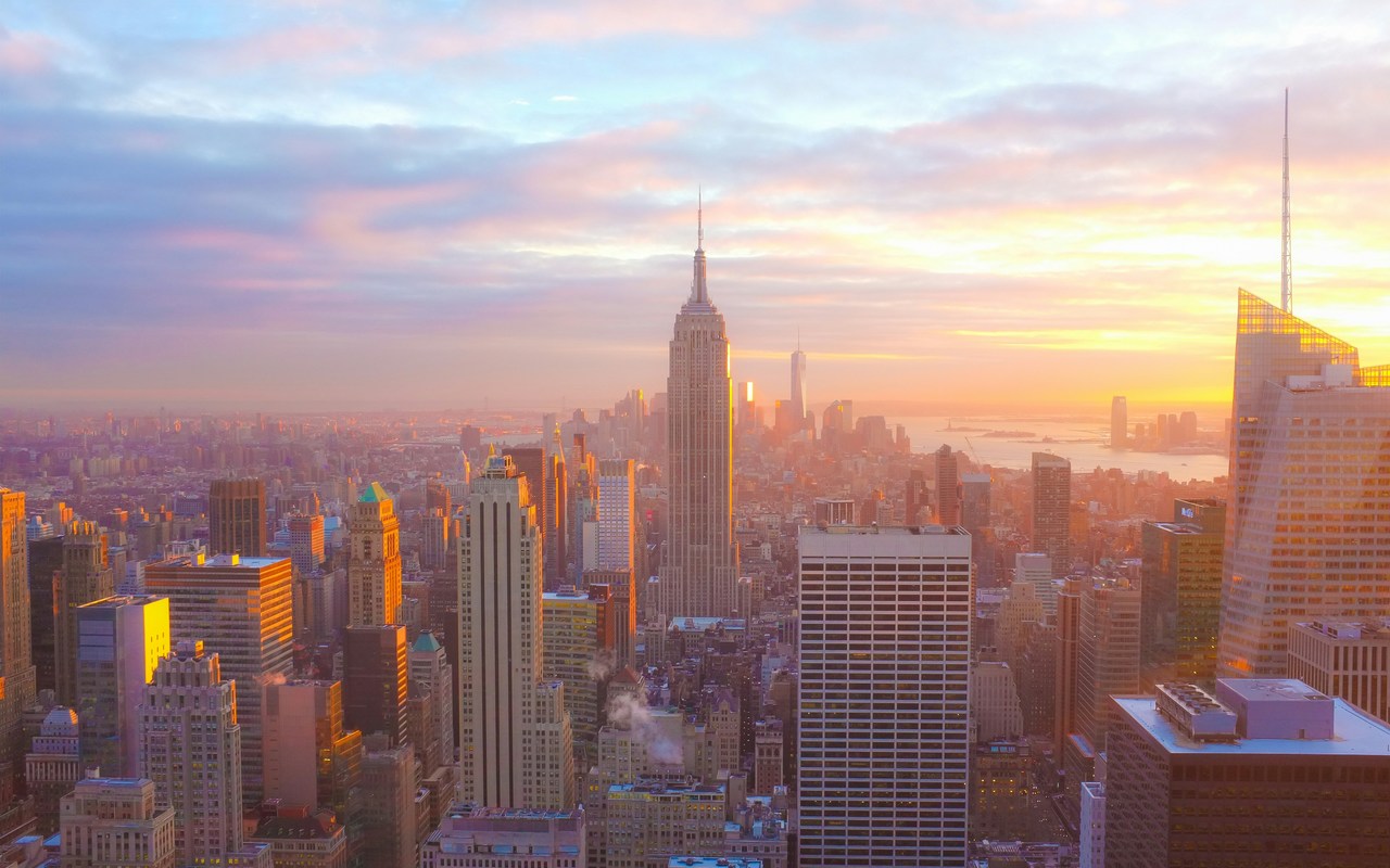 Aerial view of New York City, with the Empire State Building at center and the World Trade Center in the background.