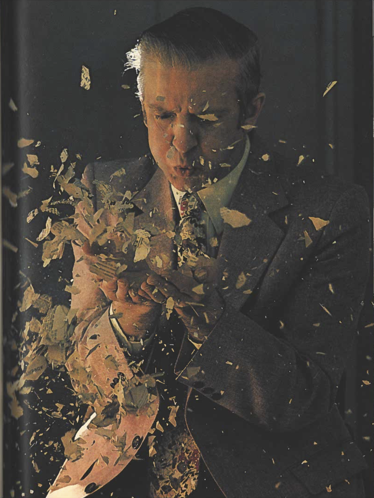 Photograph of conservator Peter Waters surrounded by paper fragments.